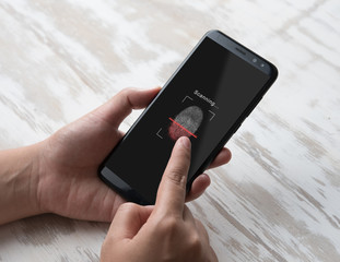 Hand holding smartphone with process of scanning fingerprint,unlock mobile phone
