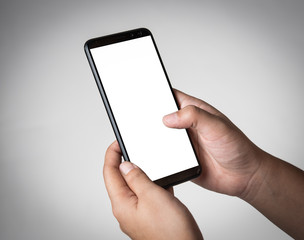 Human hand holding blank mobile smartphone on gray background