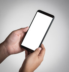 Human hand holding blank mobile smartphone on gray background