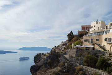 Fototapeta na wymiar Houses on Cliffs with Sea View and Cruise Ship in Fira, Santorini, Cyclades, Greece