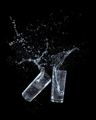 Water splashing from glass isolated on black background
