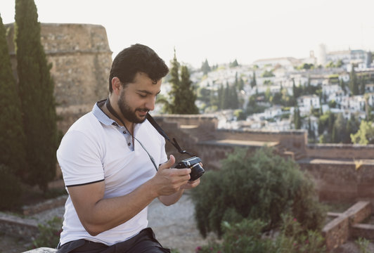 Man in La Alhambra review mirrorless evil pictures in his camera smiling in afternoon images