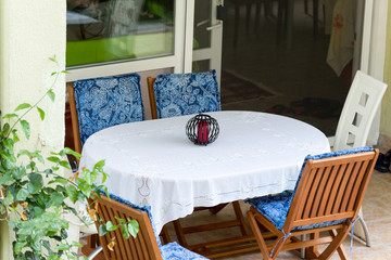 table covered with white tablecloth and chairs near house