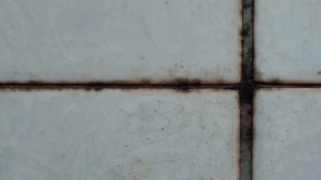 Closeup of cleaning dirty tile wall using liquid cleaner, Dolly shot

