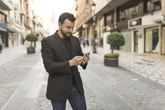 Man in street looking smartphone