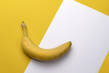 Single banana fruit isolated on yellow and white background