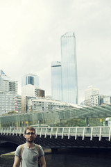 Fototapeta na wymiar Retrato de hombre joven frente a rascacielos en una gran ciudad