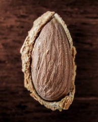 Almond nut in shell and shelled on wooden background