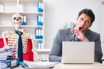Businessman working with skeleton in office
