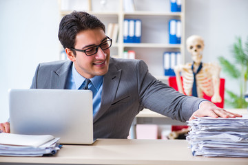 Businessman working with skeleton in office