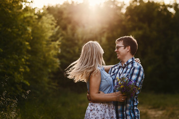 happy loving young couple hugging outdoors in sunset