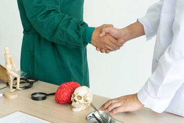 Obraz premium Two doctors check-hand in meeting plan for success operation plan at doctor office desk. Teamwork, corporation, congratulations and meeting concept.