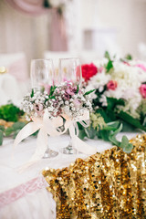 Wedding Banquet hall decorated with flowers, table setting, floral arrangements in the restaurant.