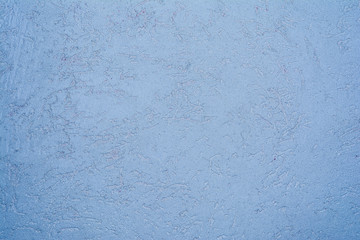 blue texture of the surface of the wall covered with decorative plaster of the woodworm type, close-up architecture abstract background