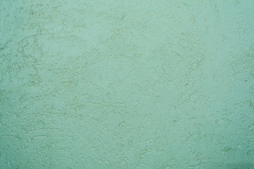 green texture of the surface of the wall covered with decorative plaster of the woodworm type, close-up architecture abstract background
