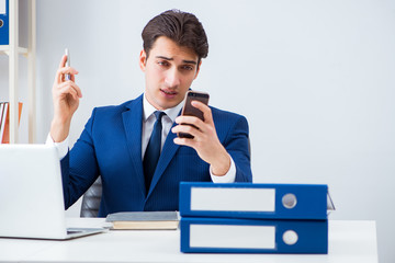 Young handsome businessman employee working in office at desk