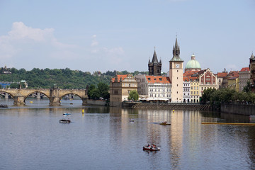 Obraz premium View of Charles Bridge, Old Town Water Tower reflected in the Vltava river with pedal boats, Prague, Czech Republic