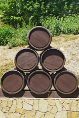 Six wine barrels, made up of a vertical pyramid on a pedestal of stone