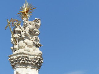 Fototapeta na wymiar Statue di Santi all'estremità di un obelisco barocco nel quartiere Buda a Budapest in Ungheria.