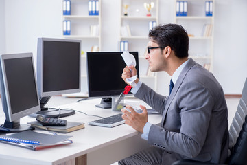 Businessman sitting in front of many screens