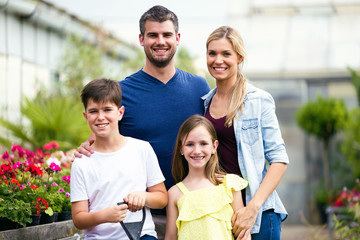 Beautiful family looking at camera in the greenhouse.