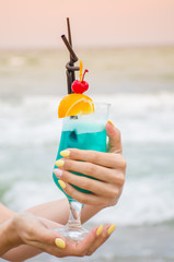 Blue coctail in the glass on the sea background