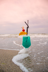 Blue coctail in the glass on the sea background
