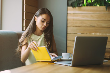 Beautiful girl working out a plan of the project and concept. Girl paints a website design on a...