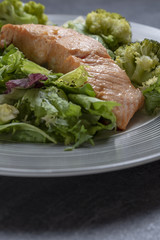 Salmon with cooked broccoli and leafy vegetables