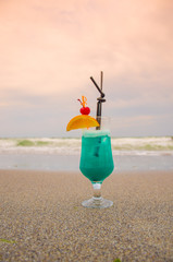 Blue coctail in the glass on the sea background