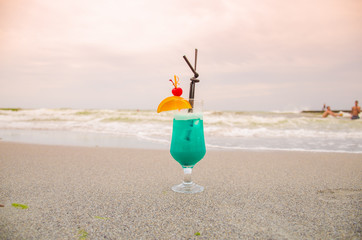 Blue coctail in the glass on the sea background
