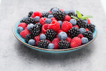 Fresh raspberries in a plate on a  vintage background.