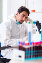 Young chemist student working in lab on chemicals
