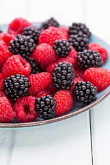 Fresh raspberries in a plate on a  vintage background.