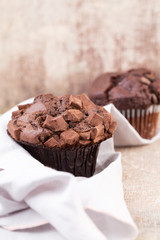 Homemade muffins with chocolate, vintage background.