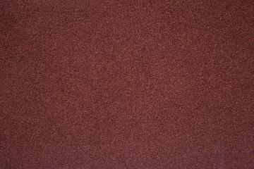 A wall covered with a stone crumb of the trendy color of a red pear