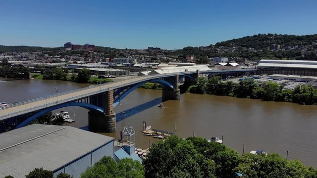 A high angle aerial slow push forward establishing shot of Pittsburgh's 31st Bridge spanning over the Allegheny River between Washington's Landing and the Lawrenceville business district.  	