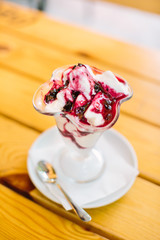 Ice cream in two retro metal bowls on a wooden table.