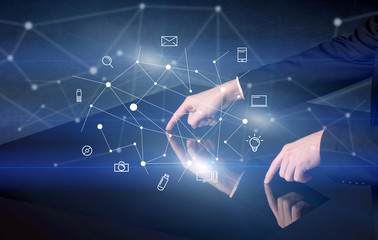 Male hands touching interactive table with blue mixed communication icons in the background