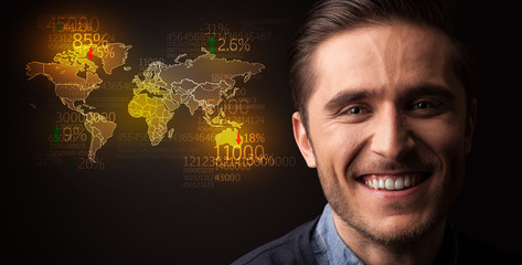 Portrait of a young businessman with a world map and numbers next to him on a dark background