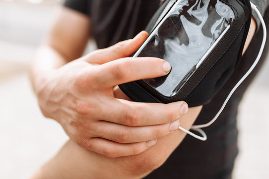 A Man Switches The Music In A Phone Case, Close-up, Morning Jog