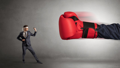 Little man fighting with a giant red boxing glove
