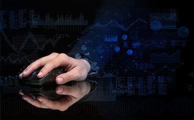 Hand using wireless mouse with financial concept on dark background
