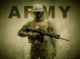 Uniformed armed soldier with damaged wall background
