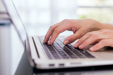 Close up view of hands over the laptop.