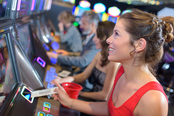female playing at the slot machines in a casino