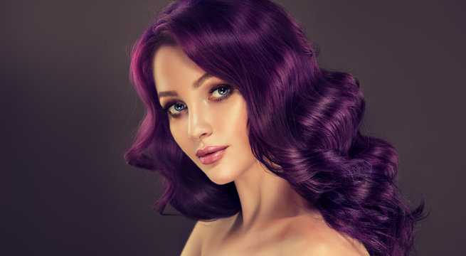 Beautiful model girl with long purple curly hair . Care products ,hair colouring .  Treatment, care and spa procedures. Medium length hairstyle. Coloring, ombre,  and highlighting . Hair coloring
