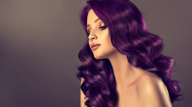 Beautiful model girl with long purple curly hair . Care products ,hair colouring .  Treatment, care and spa procedures. Medium length hairstyle. Coloring, ombre,  and highlighting . Hair coloring
