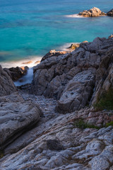 Rocky coast with foliage towards emerald waters