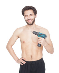 Fototapeta premium Courageous bearded young man carpenter naked to the waist is holding in his hand an electric drill is smiling and looks into the camera